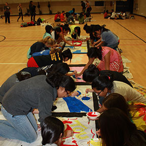 picture of students working on a banner for Homecoming